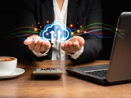 Cloud computing concept. Hand of businesswoman holding virtual cloud computing icon in the palm while sitting in the office photo