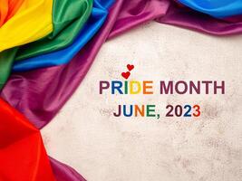 June 2023 Pride month. Top view of the rainbow flag or LGBT flag with the text over a cement floor photo