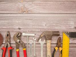 Construction tools, a hammer, screwdriver, screws, and pliers on a wooden table photo