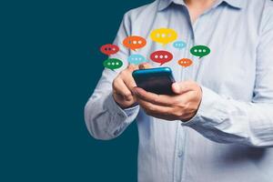 Close-up of hands using mobile phone with colorful chat icons on application communication digital web and social media photo