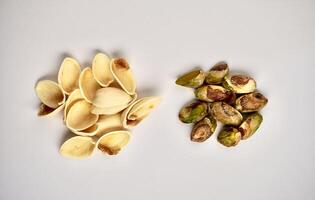 Pile of separated pistachio nuts and shell food objects isolated on horizontal white background. photo