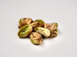Pile of pistachio nuts without shells isolated on horizontal white background. photo