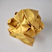 Discarded idea concept. One piece of crumpled brown kraft paper ball object isolated on square background. photo