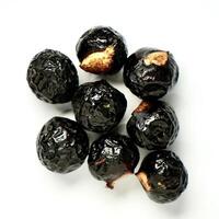 Group of black or dark brown colored soap berry nuts or buah lerak isolated on square white background. photo