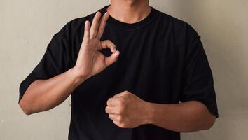 Young man showing sign language gesture during online lesson photo