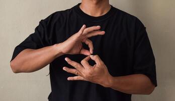 Young man learns sign language to talk, hand gestures of people with hearing impairment photo