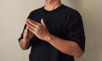 Sign Language man interpreter gesturing in sign language on gray background photo