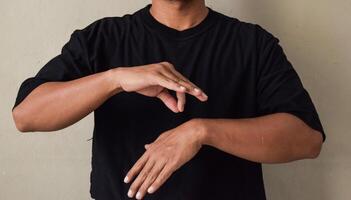 Young man learns sign language to talk, hand gestures of people with hearing impairment photo