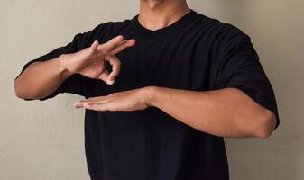 Young man showing sign language gesture during online lesson photo