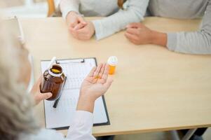 A close-up of a doctor explaining the instructions for the medication to a patient during the visit. photo