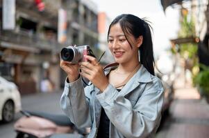 A happy Asian female tourist enjoying taking photos with her camera while exploring the city.