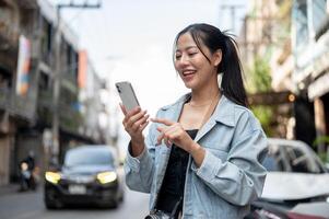 A happy female tourist using her smartphone to check directions on an app while exploring the city. photo