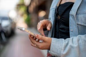 A tourist using her smartphone to check directions on an app while exploring the city. photo