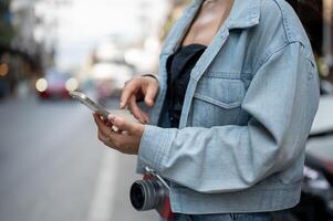 A tourist using her smartphone to check directions on an app while exploring the city. photo