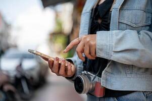 A tourist using her smartphone to check directions on an app while exploring the city. photo