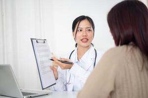 A doctor showing a medical paper to a patient while discussing the treatment plan at the hospital. photo