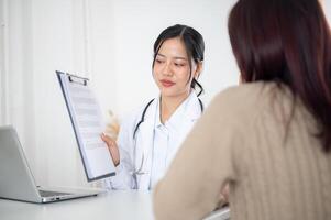 A doctor showing a medical paper to a patient while discussing the treatment plan at the hospital. photo