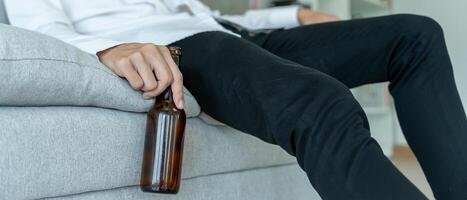 Depressed young business man addicted feeling bad drinking whiskey alone at home, stressed frustrated lonely drinking alcohol suffers from problematic liquor, alcoholism, life and family problems photo