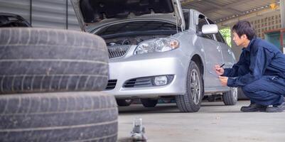 mechanic is doing the annual car inspection. Car repair shop is ready to serve. Car mechanic inspects car engine problems technical inspection engine safety Maintenance Changing the engine oil photo
