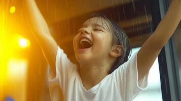 A child is laughing and standing in front of a window photo