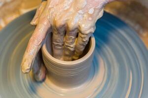 womens hands of a potter creating an earthen jar photo