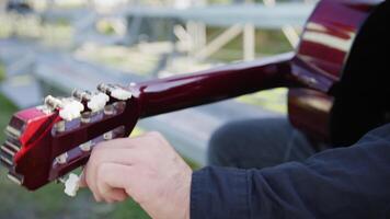 A Man's Hand Turns The Wrench To Tune The Strings Of The Classical Guitar video