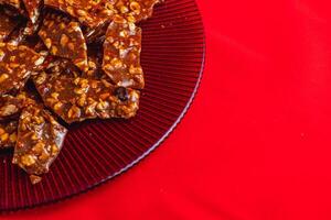 Homemade sugar cookies with nuts on a shiny red plate photo