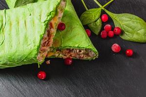 Homemade shawarma with spinach filled with chicken, vegetables and cranberries photo