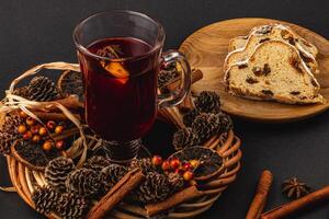 Festive Christmas mulled wine with stollen on a black background photo