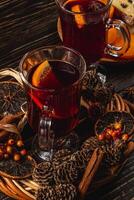 aromatic mulled wine with spices on a piece of wood on a black background photo