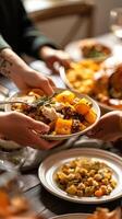 Close-Up of Hands Passing Dishes at a Festive Thanksgiving Table Loaded with Food. Concept of Family Gathering, Holiday Celebration, Traditional Feast. Vertical photo