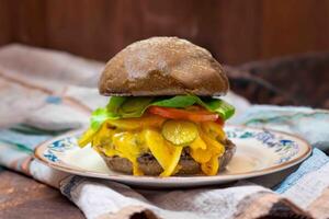 Traditional rustic burger sandwich with cheddar cheese, vegetables and Australian bread in creative photography and cozy village setting photo