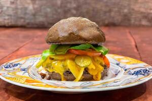 Traditional rustic burger sandwich with cheddar cheese, vegetables and Australian bread in creative photography and cozy village setting photo