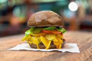 Traditional rustic burger sandwich with cheddar cheese, vegetables and Australian bread in creative photography and cozy village setting photo