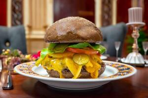 Traditional rustic burger sandwich with cheddar cheese, vegetables and Australian bread in creative photography and cozy village setting photo