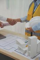 Construction and structure concept of Engineer or architect meeting for project working with partner and engineering tools on model building and blueprint in working site, contract for both companies. photo