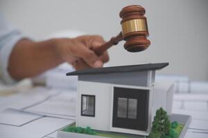 Judge gavel on building blueprint plans with a yellow safety helmet in the background. law that deals with matters relating to building construction, engineering. Construction law concept. photo