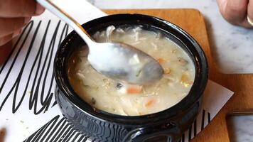 A Mouthwatering Bowl of Rich and Creamy Soup Served Lovingly in a Rustic Black Pot video
