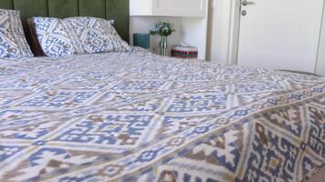 Modern bedroom designed with green accents and a bedspread showcasing intricate patterns video