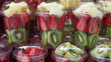 pineapple, kiwi and Strawberries in. plastic container selling at shop video