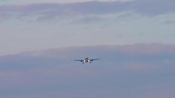 Long shot of unknown aircraft with headlights on descending approaching landing video