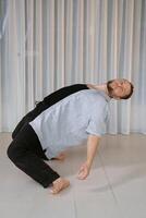 A man performs a randomized movement for yoga at a fitness gym photo