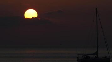 Cloudy beautiful sunset on the sea. Seascape in the twilight of the evening. Silhouette of a yacht floating near the shore video