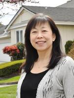 Smiling woman outside in front of her new home house portrait photo