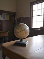 Globe in a school classroom primary educate geography map on a desk photo