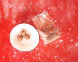 Sweet truffels on red background in snowfall. photo
