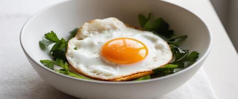 Freshly cooked sunny side up eggs in a bowl with herbs. photo