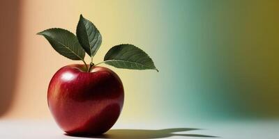 Red Apple with Green Leaves on Yellow and Teal Background. photo