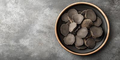 Whole and sliced black truffles arranged neatly on a serving platter, food photography photo
