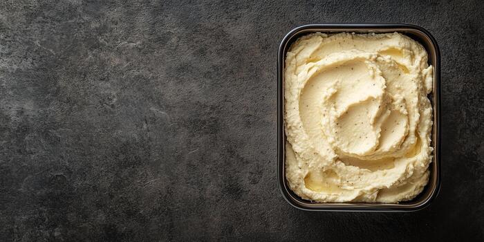 Hummus displayed in a rectangular container with an even texture and no extra components, photorealistic food photo